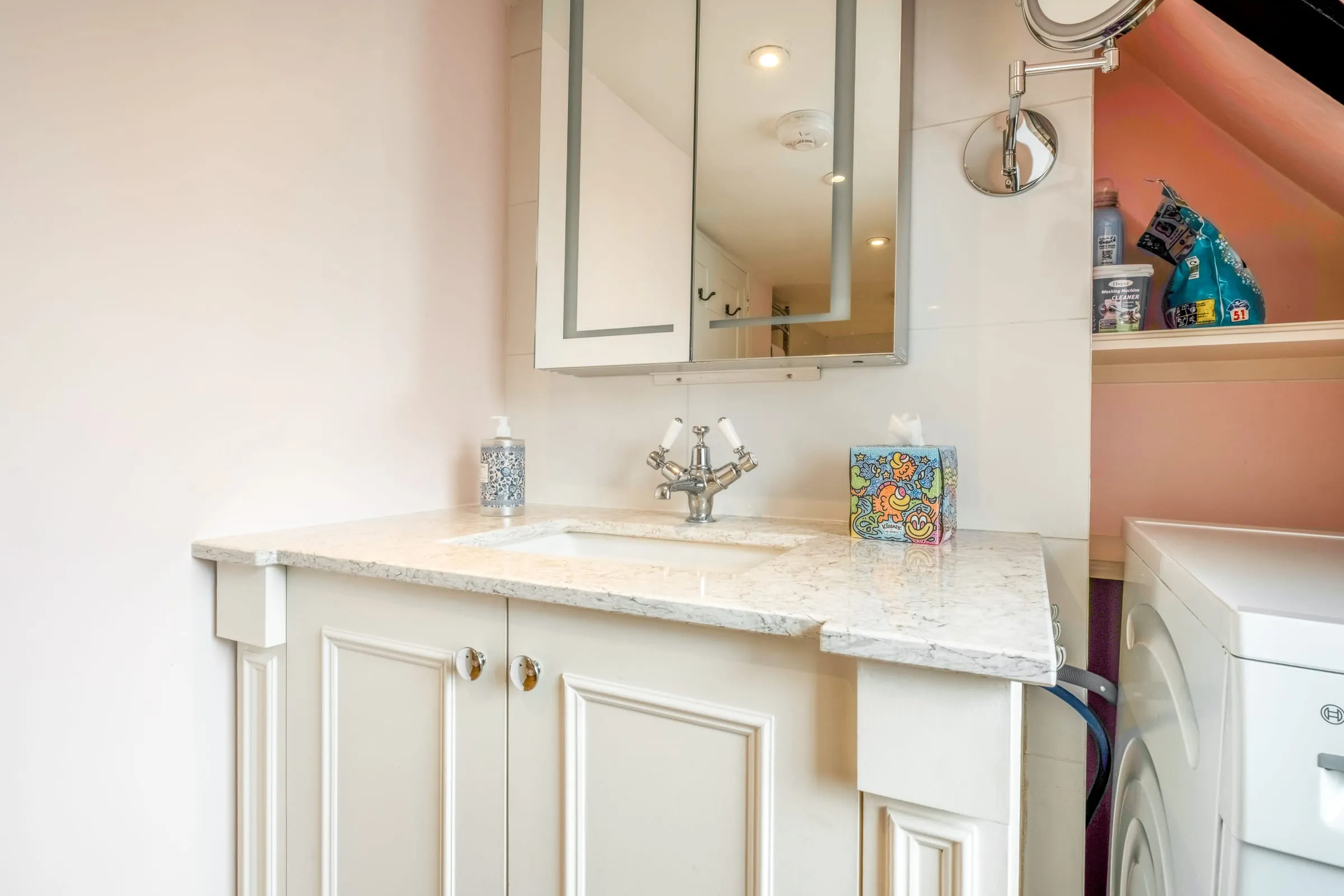 Bathroom vanity with marble top, mirrored cabinet and toiletries