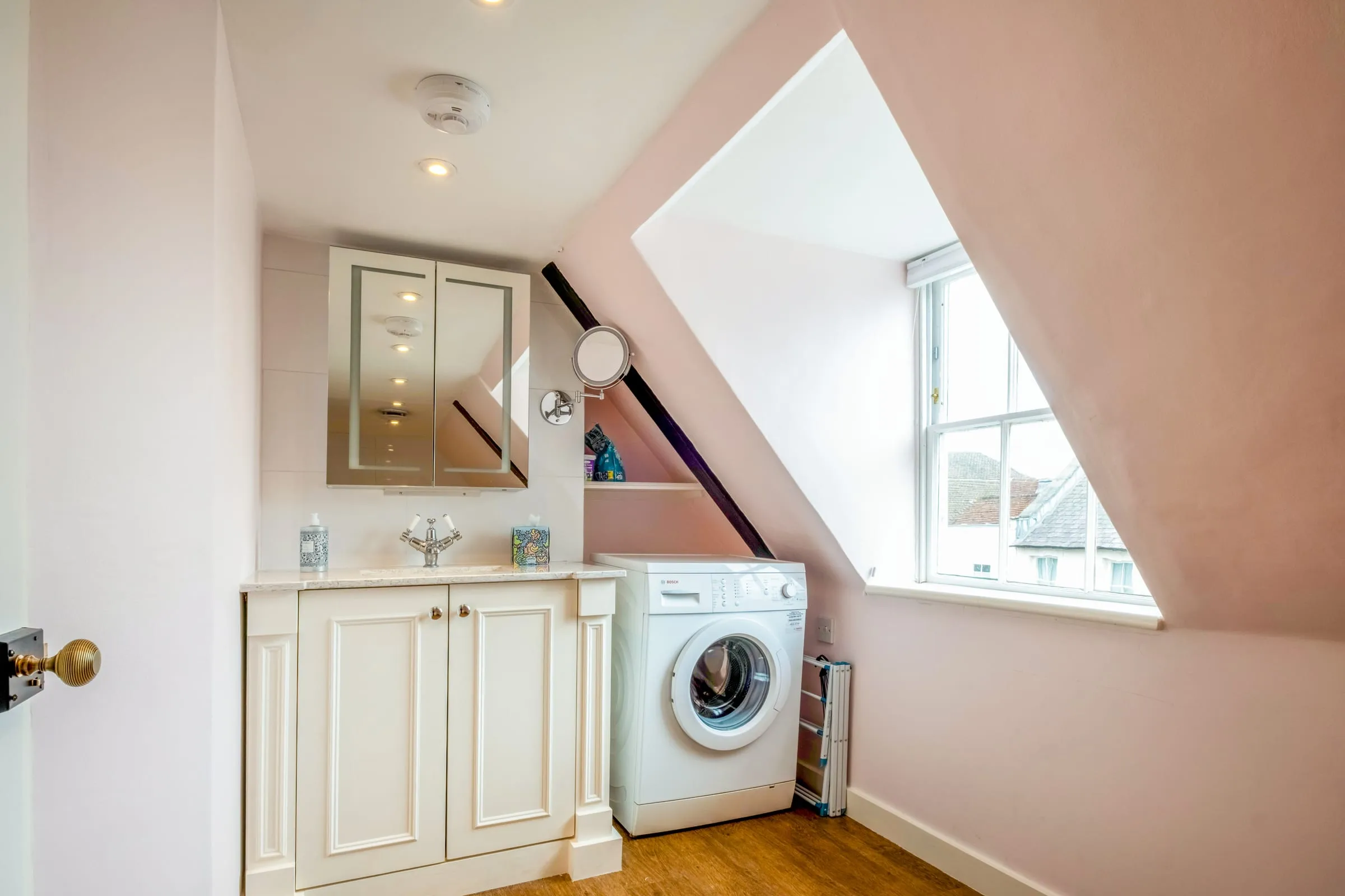 Bathroom with vanity basin, washing machine and a dormer window