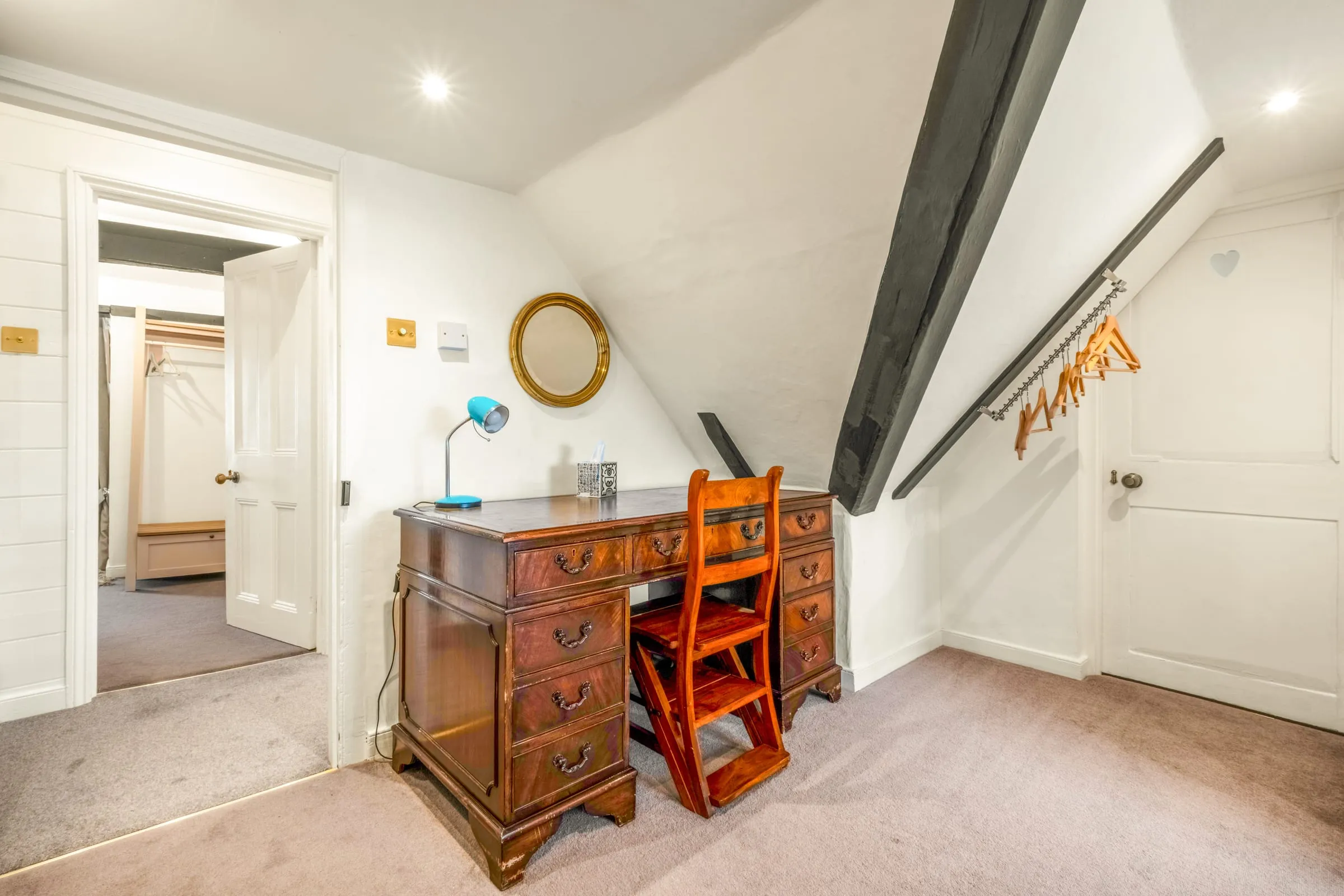 Antique writing desk with a chair and lamp under the eaves, for remote working