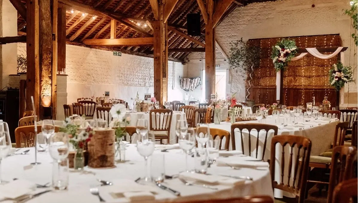 Wedding breakfast laid out under the timber roof of a Sussex barn